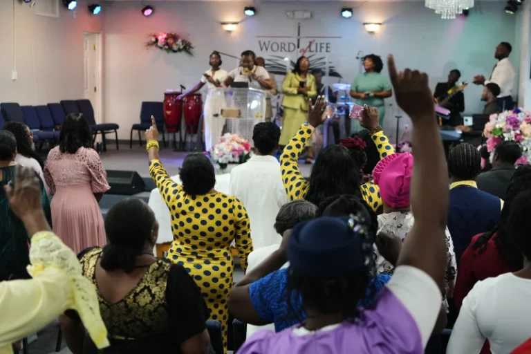 (Members of the Word of Life Center, a church and hub of the Haitian community, sing and pray during a service.  AP Photo: Luis Andres Henao)