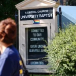 (People walk by a sign outside University Baptist Church, Friday, Sept. 4, 2026, in Minneapolis.  AP Photo: Ellen Schmidt)