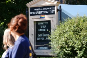 (People walk by a sign outside University Baptist Church, Friday, Sept. 4, 2026, in Minneapolis.  AP Photo: Ellen Schmidt)