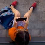 (A child plays with his father's phone outside a school in Barcelona, Spain, Monday, June 17, 2024.  AP File Photo: Emilio Morenatti)