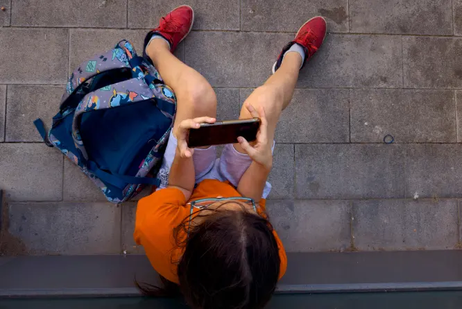 (A child plays with his father's phone outside a school in Barcelona, Spain, Monday, June 17, 2024.  AP File Photo: Emilio Morenatti)