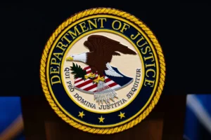 (The U.S. Department of Justice logo is seen on a podium before a news conference, May 4, 2026, in Washington.  AP File Photo: Julia Demaree Nikhinson)