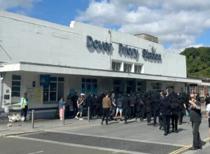(Protesters gather at Dover Priory train station after black-clad and masked demonstrators blocked roads during a protest, in Dover, England, Saturday, Sept. 5, 2026.  Photo: Oscar Rihll-PA via AP)