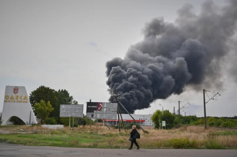 (A woman walks by the burning warehouse at the city entrance following Russian air attack in Odesa, Ukraine, Sunday, Sept. 13, 2026. AP Photo: Michael Shtekel)