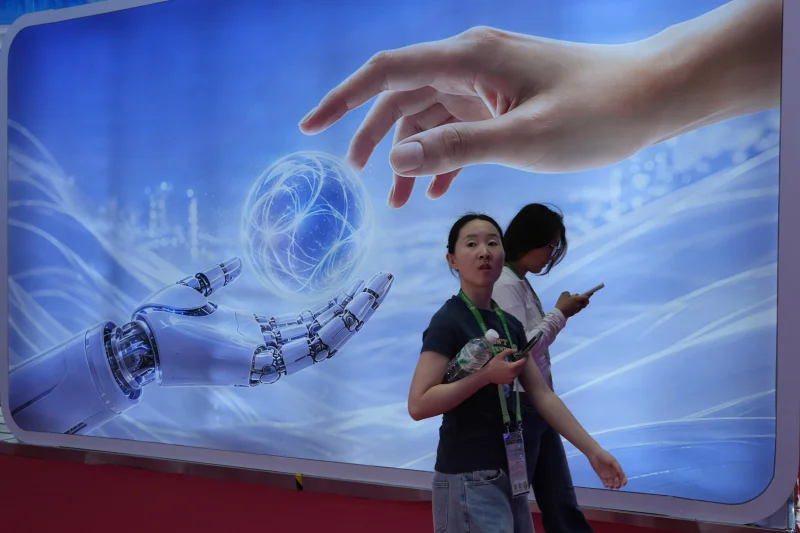 (Visitors walk past a display depicting artificial intelligence and a human hand at the China International Supply Chain Expo in Beijing on Monday, June 22, 2026.
AP Photo: Ng Han Guan)