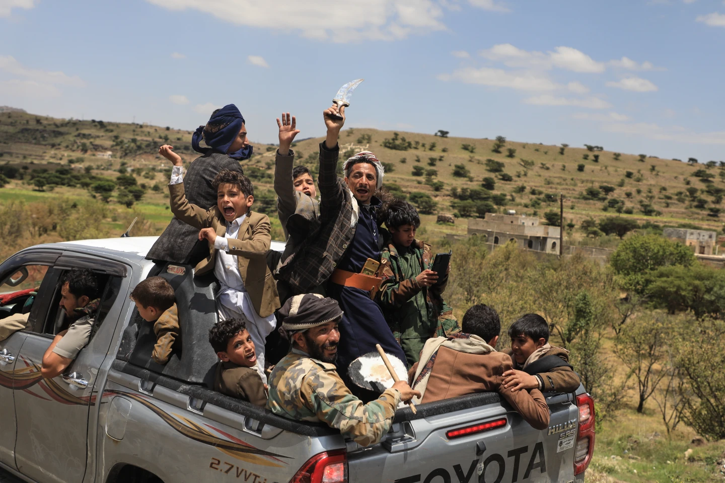 (Yemeni civilians celebrate while riding in the back of a pickup truck in the Bani Matar district, Yemen, Saturday, Sept. 12, 2026, as they follow a convoy carrying Houthi prisoners freed in Mokha on its way to Sanaa following the Houthi takeover of the southern Red Sea port city. Credit: AP-STR)
