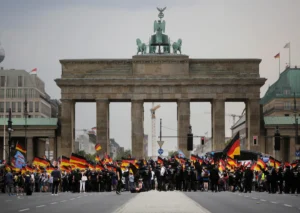 (AfD supporters wave AfD flags and German national flags during a demonstration in front of the Brandenburg Gate in Berlin, Germany, May 27, 2018. AP Photo: Markus Schreiber, File)