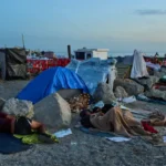 (Migrants, some of them minors, sleep on El Trampolín Beach in the Spanish enclave of Ceuta, Thursday, Oct. 1, 2026.  AP Photo: Bernat Armangue)